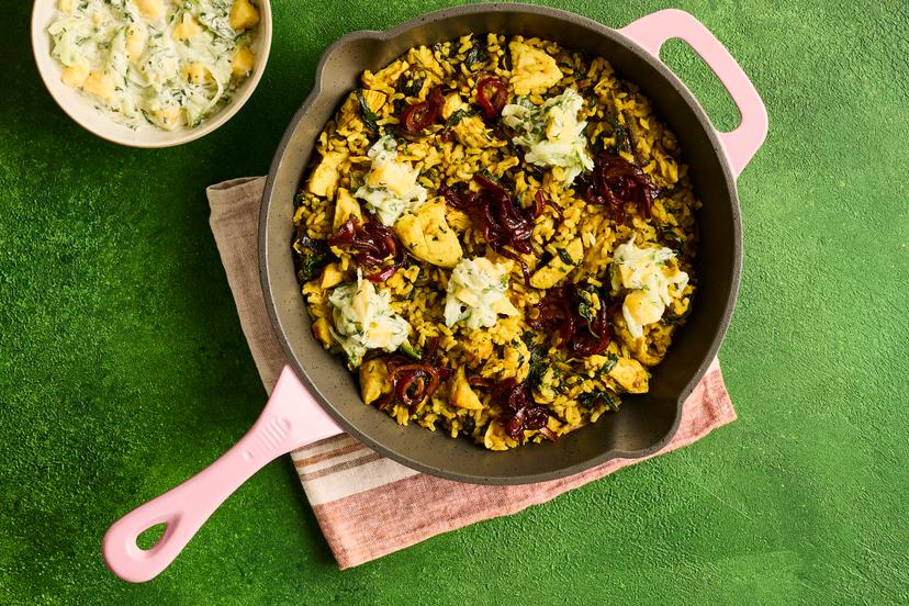 This warming curried rice dish is crammed with deliciousness, from the charred, spiced shreds of chicken and caramelised red onion topping, to a refreshingly fruity raita. When cooking from scratch is as easy and delicious as this, who needs takeout?