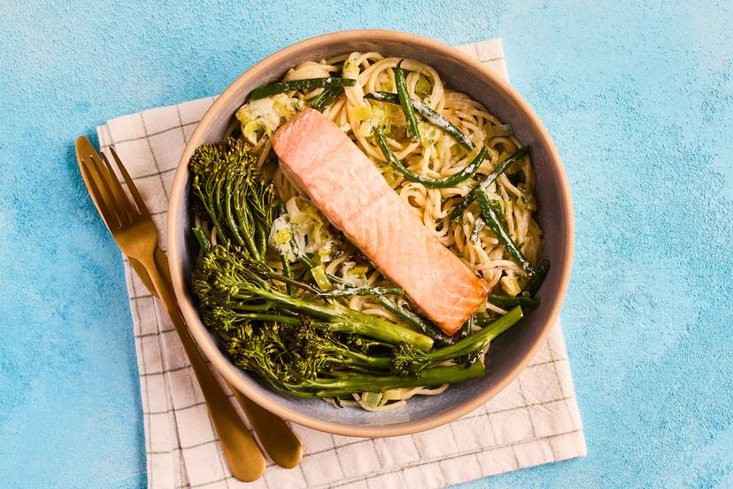 A perfect dish for midweek: spaghetti in a garlicky, herby sauce with leeks and green beans is topped with salmon fillets and roasted long-stem broccoli. Finished with a squeeze of lemon, itʼs simple, stylish and totally delicious.