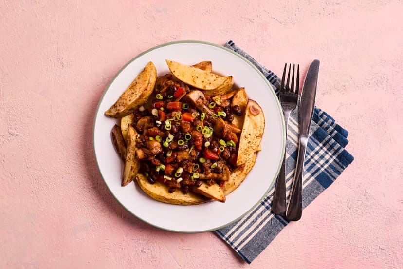 A sprinkling of Mexican spice breathes new life into golden potato wedges. They’re topped with a saucy medley of mushrooms, black beans, onion and pepper, flavoured with chilli, lime, coriander, sun-dried tomato paste and, yes, more Mexican spice! A scattering of spring onions adds a final flavour boost.