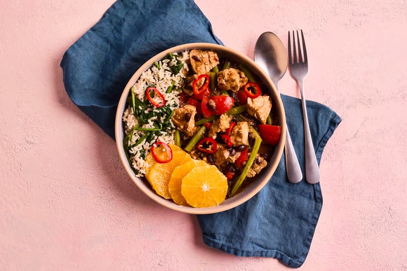 Get set for a carnival of flavour! This tasty medley of chicken breast chunks, black beans, red pepper and green beans is livened up with tempero baiano (a colourful spice blend of chilli, cumin, oregano and parsley) and served on a base of spinach-flecked brown rice. Slices of orange and chopped chilli add a final flourish.