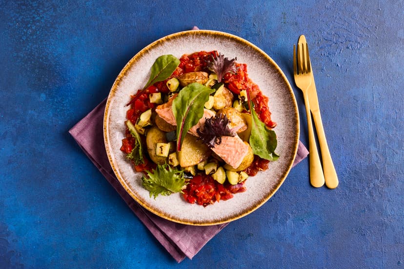 Vibrantly red romesco sauce is made with roasted red peppers, red onion and tomatoes and a hint of smoky paprika. Our Slimming World-friendly version is served with salmon fillets and roasted baby potatoes and courgettes.