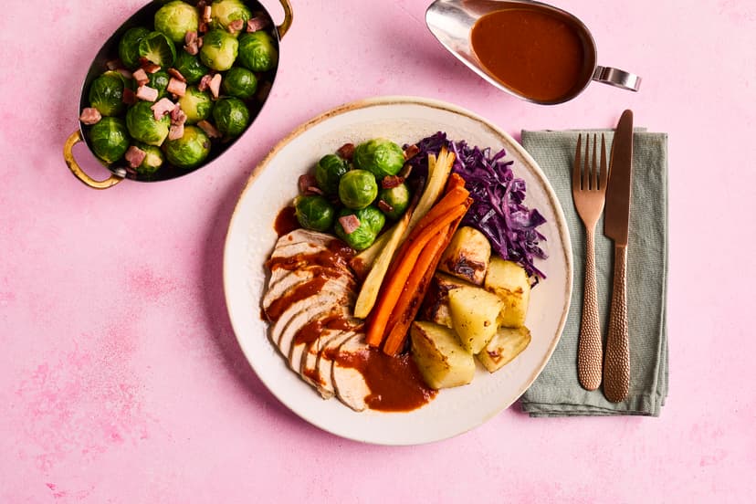 Take your places for our flavoursome feast of garlic and herb-rubbed chicken breasts, thyme-roasted parsnips, carrots and potatoes, Brussels (with smoky bacon, to win over those sprout sceptics!), braised red cabbage and a rich garlic and herb gravy. It’s a cracker!