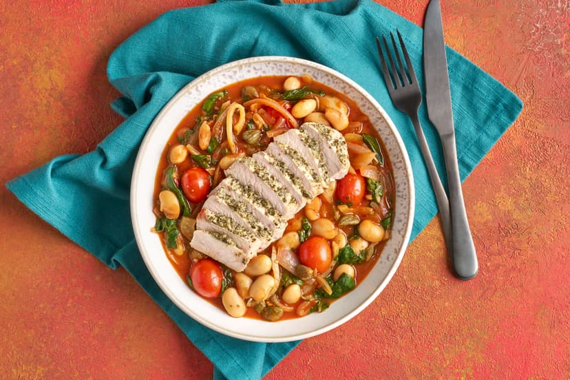 We've given pork and beans a glow up – with irresistible results! Pork loin is smothered in our garlicky herb paste and grilled, while a speedy stew of onion, fennel, tomatoes and butter beans simmers on the hob. Capers, chilli and lemon elevate everything, then spinach and the tender sliced pork finish the dish.